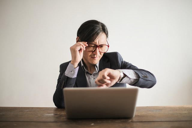 businessman looking at a watch representing cultural differences between the US and Japan