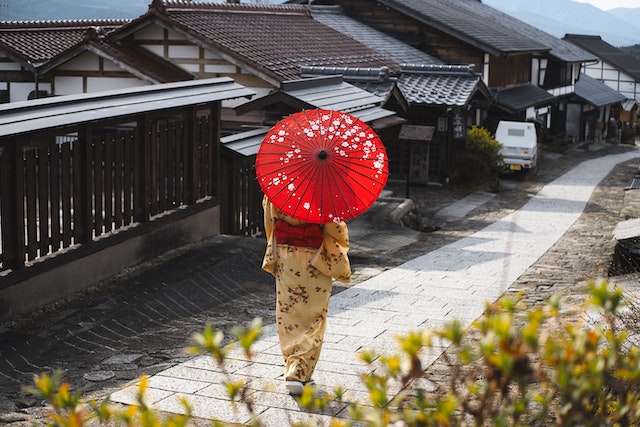 woman in kimono holding an umbrella depicts mesmerizing cities in Japan for history lovers